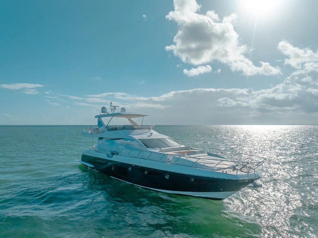 Luxury 75ft Azimut yacht cruising on clear blue Miami waters for charter.