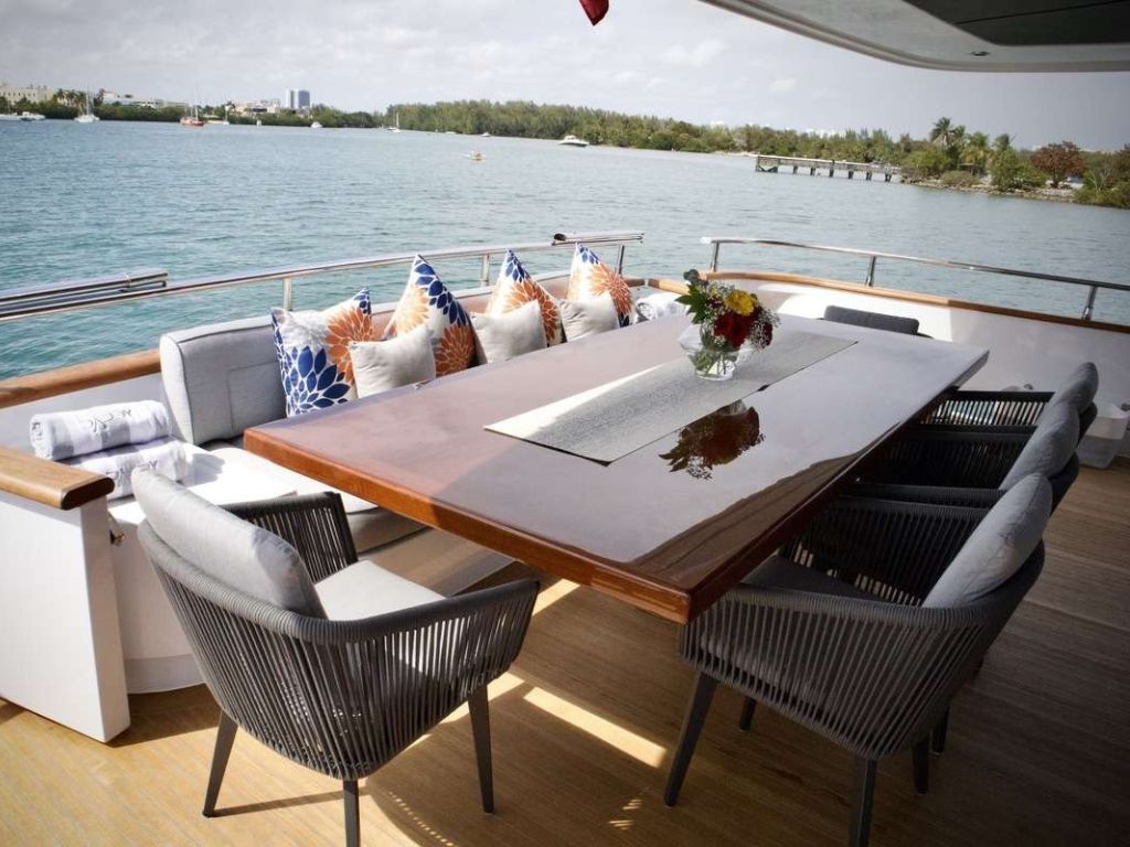 Guests enjoying a meal on the outdoor deck of the 108 San Lorenzo yacht at sunset
