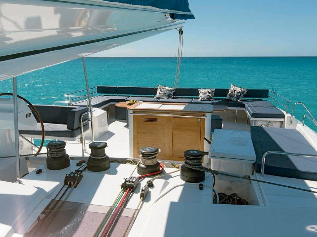 Guests relaxing on the front deck of 70 Fountaine Pajot yacht