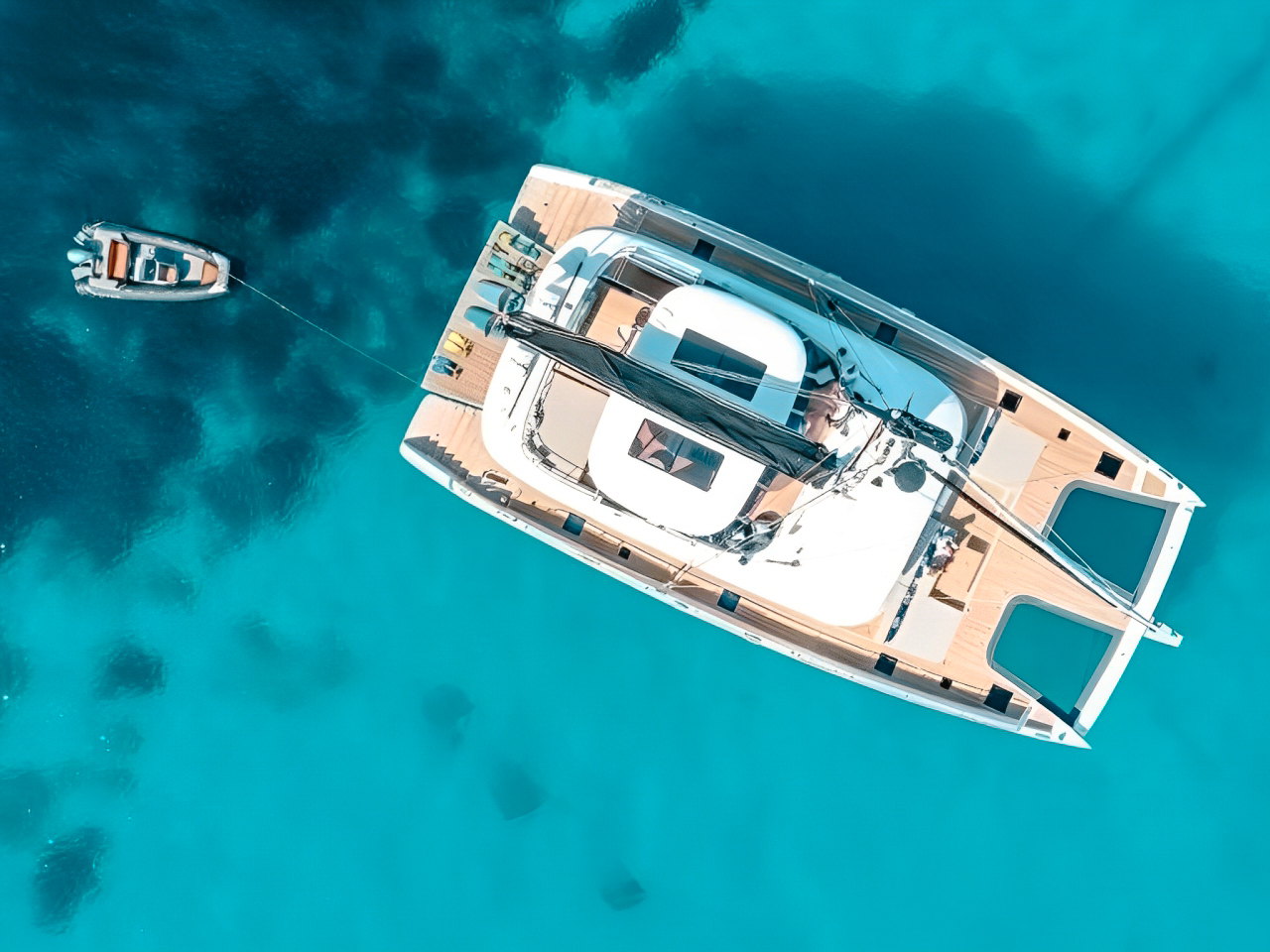 A group of people relaxing on the foredeck net of 80 Sunreef I yacht