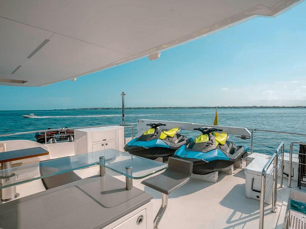 A guest on the swimming platform of 90 Horizon yacht with water toys