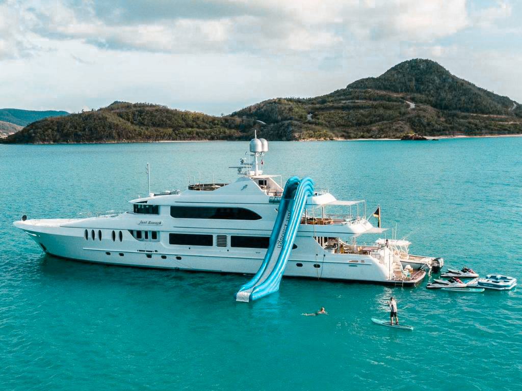 Luxury 141ft Ares Marine yacht sailing in clear turquoise Caribbean waters with guests visible on deck.