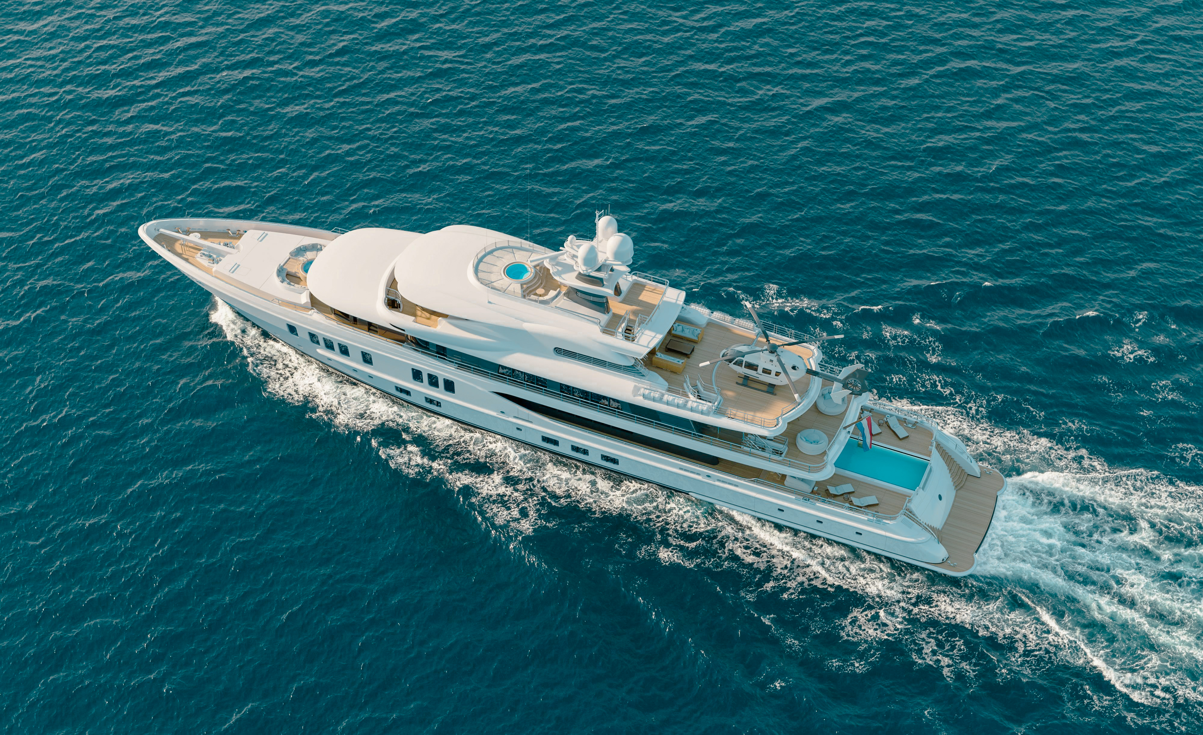 Front exterior view of the 242 Amels yacht with blue skies
