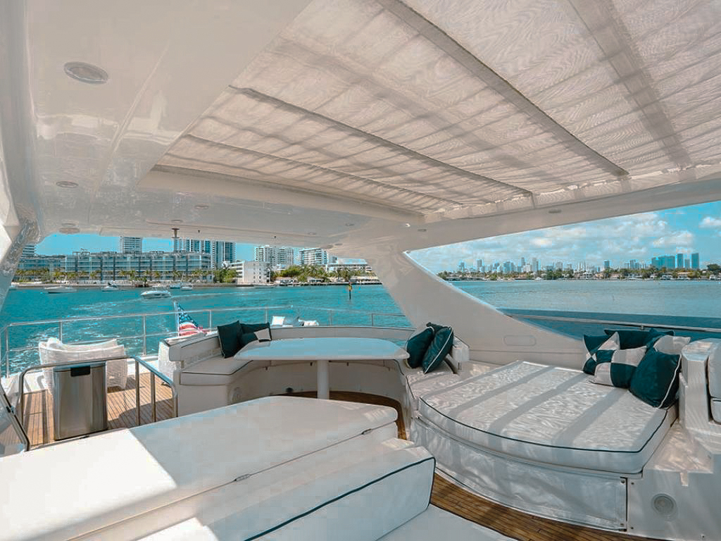 76 Ferretti yacht flybridge with dining table and seating under an awning