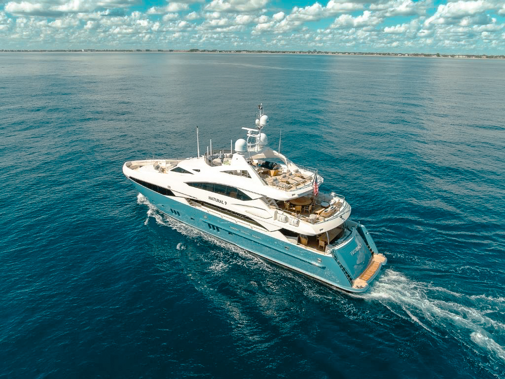 Luxurious 135-foot Alia superyacht docked in a beautiful harbor for charter.