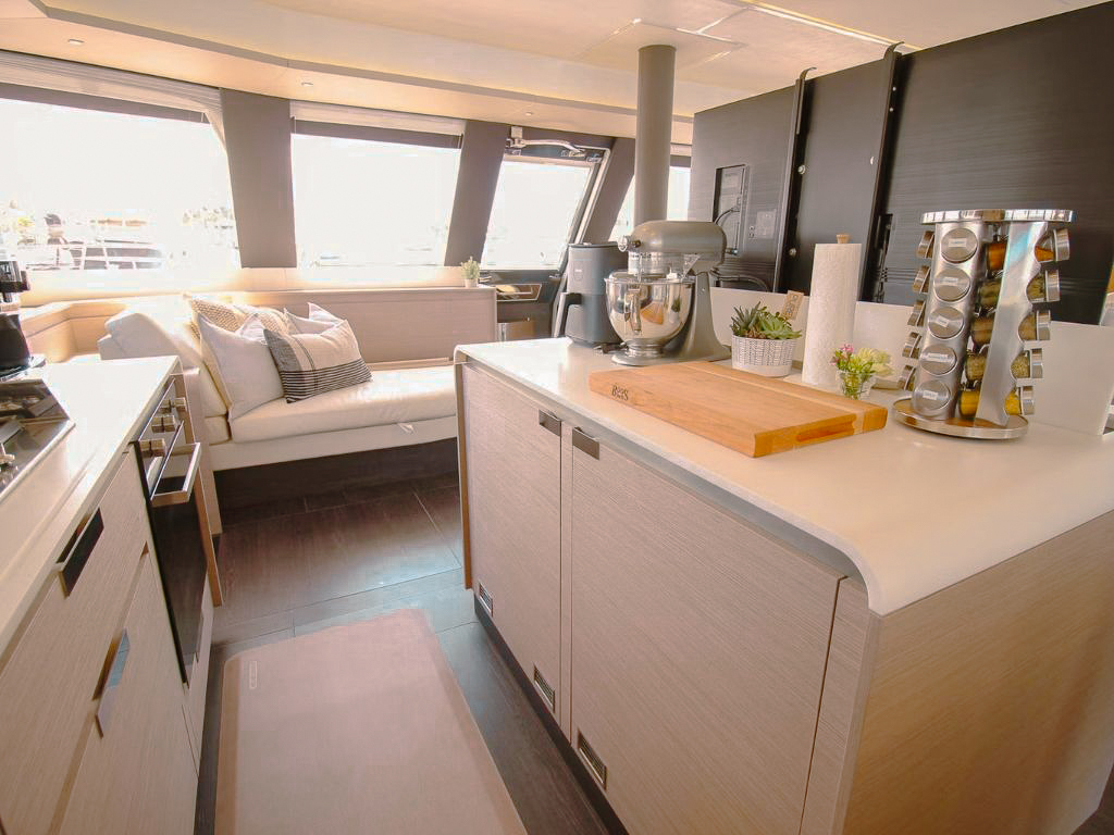 A person relaxing on the bow trampolines of the 67 Fountaine Pajot yacht