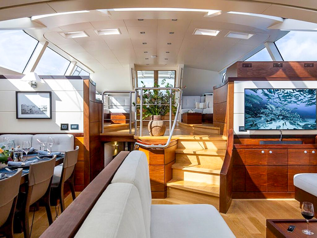 Master cabin in 131 Custom Sail yacht with bed and seating area