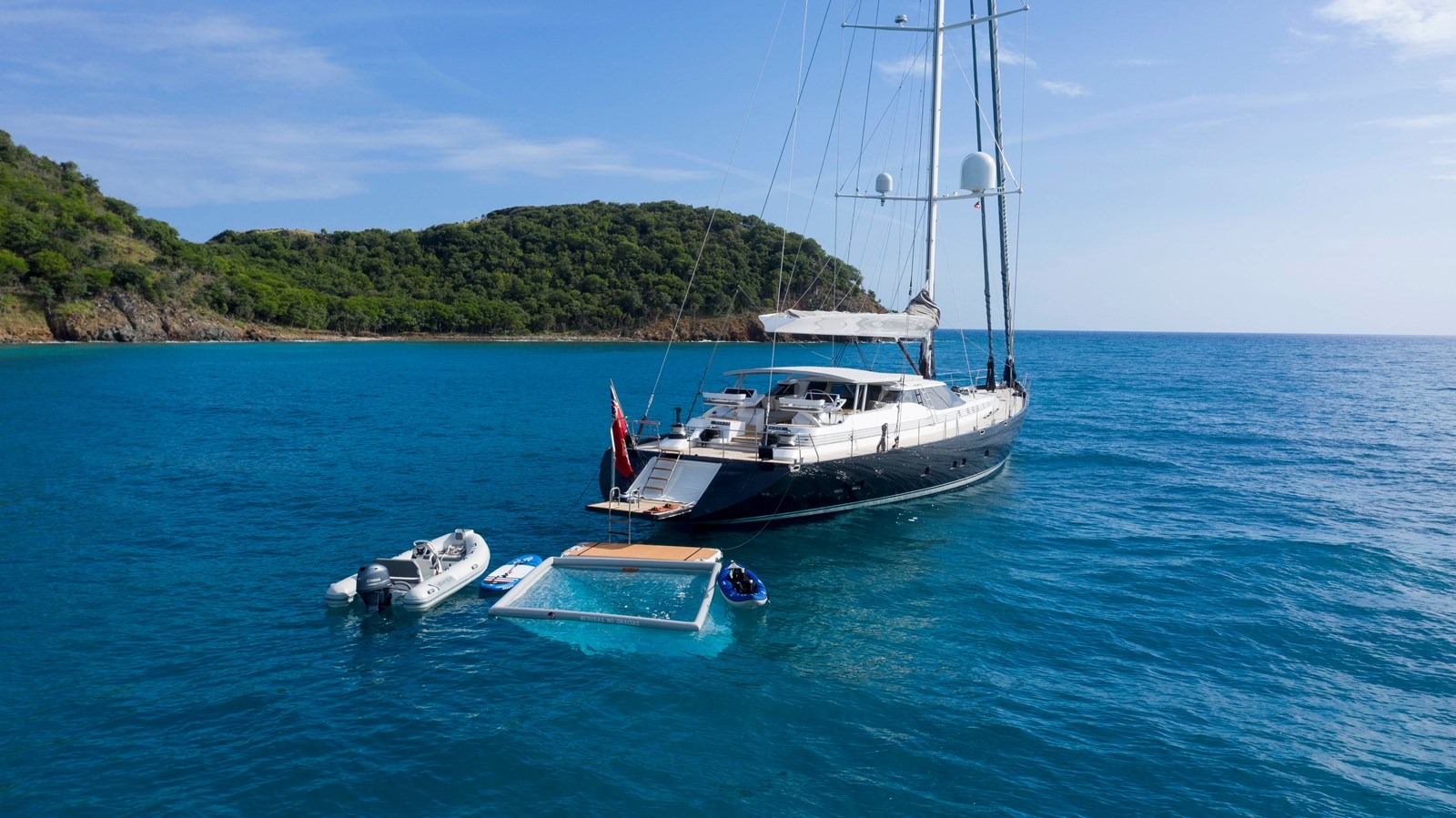 A person relaxing in the jacuzzi on the deck of 131 Custom Sail yacht