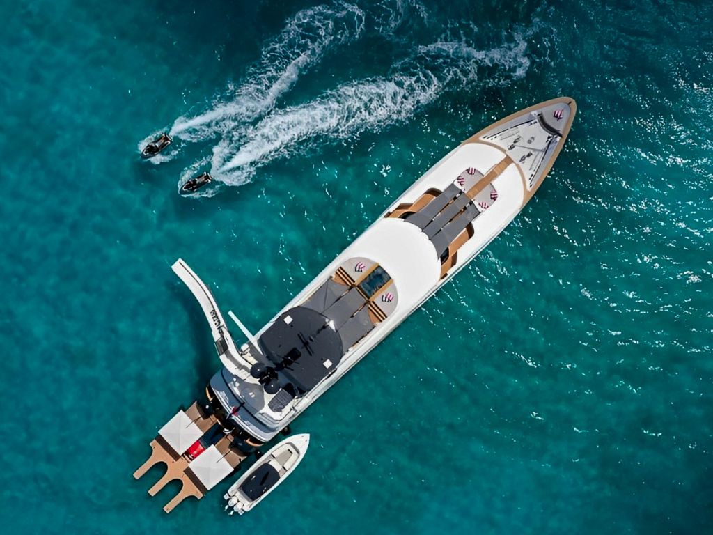 A large yacht anchored in clear blue waters at sunset